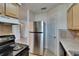 Functional kitchen with stainless steel refrigerator and essential appliances, ready for everyday cooking at 1920 E Edgewood Dr # D7, Lakeland, FL 33803