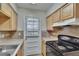 Functional kitchen showcasing countertops, wood cabinets, stainless sink, and modern appliances at 1920 E Edgewood Dr # D7, Lakeland, FL 33803