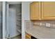 Kitchen pantry with multiple shelves for ample storage, and wood kitchen cabinets at 1920 E Edgewood Dr # D7, Lakeland, FL 33803