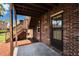 Covered patio with brick walls, concrete floor, and access to a lush backyard through a glass-paned door at 1920 E Edgewood Dr # D7, Lakeland, FL 33803