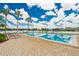 Inviting community pool surrounded by lounge chairs, palm trees, and a serene lake backdrop at 1920 E Edgewood Dr # D7, Lakeland, FL 33803