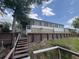 Charming home featuring an enclosed porch, elevated wooden deck, and waterfront access; ideal for enjoying peaceful lakeside living at 2055 S Floral Ave # 262, Bartow, FL 33830