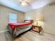 This cozy bedroom features wood-look flooring, a ceiling fan, and natural light from the window at 2055 S Floral Ave # 291, Bartow, FL 33830