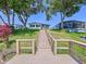 Home's backyard has stairs down to a lake with nice landscaping, trees and beautiful clear skies at 2055 S Floral Ave # 291, Bartow, FL 33830