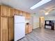Kitchen featuring wood cabinets and flooring, black appliances, and a white refrigerator at 2055 S Floral Ave # 291, Bartow, FL 33830
