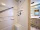 Clean, white tiled shower featuring a showerhead with a detachable spray nozzle and accessibility grab bar at 2055 S Floral Ave # 291, Bartow, FL 33830
