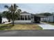 Charming single-story home featuring a covered carport, a palm tree, and a screened front porch at 2055 S Floral Ave # 45, Bartow, FL 33830