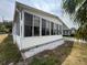 Exterior view featuring a glass-enclosed porch with a well-manicured garden bed at 2055 S Floral Ave # 45, Bartow, FL 33830