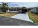 Charming single-story home featuring a covered carport, a palm tree, and a screened front porch at 2055 S Floral Ave # 45, Bartow, FL 33830