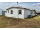 Exterior view of a mobile home featuring wood shutters, a grass yard and a visible AC unit at 2055 S Floral Ave # 45, Bartow, FL 33830