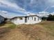 Exterior angle view showing a screened porch and grass yard around the home at 2055 S Floral Ave # 45, Bartow, FL 33830