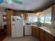 Functional kitchen featuring oak cabinets, white appliances, and a window over the sink offering great lighting at 2055 S Floral Ave # 45, Bartow, FL 33830