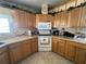 Functional kitchen featuring oak cabinets, white appliances, and a window over the sink offering great lighting at 2055 S Floral Ave # 45, Bartow, FL 33830