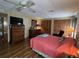 Comfortable main bedroom with ceiling fan, wood floors and dresser with mirror at 2055 S Floral Ave # 45, Bartow, FL 33830