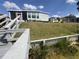 View of the gray home from the water, featuring a screened-in porch and well-maintained lawn at 2055 S Floral Ave # 69, Bartow, FL 33830