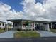 Charming home with a covered driveway, complemented by a beautifully landscaped yard and red window frames at 2055 S Floral Ave # 69, Bartow, FL 33830