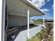 Inviting covered porch with gray flooring, leading to a well-maintained home and yard at 2055 S Floral Ave # 69, Bartow, FL 33830