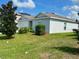 Exterior of a well-maintained single story home with attractive landscaping at 264 Fiddlewood Ct, Davenport, FL 33837