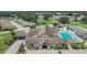 Aerial view of clubhouse with pool, tennis court and parking area, surrounded by golf course in a 55+ community at 3154 Prairie Dunes W Cir, Lakeland, FL 33810