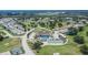 An aerial shot shows the community clubhouse, pool, tennis court, and golf course amidst a 55+ neighborhood at 3154 Prairie Dunes W Cir, Lakeland, FL 33810