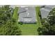 An aerial view of a house surrounded by a green lawn and mature trees at 3154 Prairie Dunes W Cir, Lakeland, FL 33810