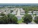 An aerial view of a neighborhood with houses and tree-lined streets under a sunny sky at 3154 Prairie Dunes W Cir, Lakeland, FL 33810