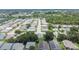 Aerial view of a neighborhood with houses and tree-lined streets near a pond at 3154 Prairie Dunes W Cir, Lakeland, FL 33810