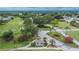 Aerial view of entrance into community featuring landscaping and putting green, with golf course and residential area beyond at 3154 Prairie Dunes W Cir, Lakeland, FL 33810