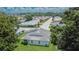An aerial view of a neighborhood with houses and tree-lined streets under a sunny sky at 3154 Prairie Dunes W Cir, Lakeland, FL 33810