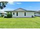 A backyard view of a house featuring a well maintained lawn and a clean white siding at 3154 Prairie Dunes W Cir, Lakeland, FL 33810