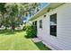 Side view of house showing backdoor, manicured lawn, and lush landscaping near the home at 3154 Prairie Dunes W Cir, Lakeland, FL 33810