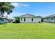 Spacious backyard with lush green grass and a well-maintained white house exterior at 3154 Prairie Dunes W Cir, Lakeland, FL 33810