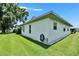 Side view of a house with well-kept lawn, clean white siding, and a lush tree nearby at 3154 Prairie Dunes W Cir, Lakeland, FL 33810