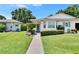 Front of a well-maintained home with manicured lawn, mature landscaping, and charming curb appeal at 3154 Prairie Dunes W Cir, Lakeland, FL 33810