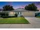 Inviting single-story home with manicured lawn and a two-car garage at dusk at 3154 Prairie Dunes W Cir, Lakeland, FL 33810