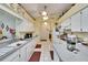 Bright kitchen featuring white cabinetry, countertops, appliances, and a view to the bathroom at 3154 Prairie Dunes W Cir, Lakeland, FL 33810