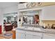 Kitchen featuring white countertops, a double sink, and a breakfast bar with views to the living room at 3154 Prairie Dunes W Cir, Lakeland, FL 33810