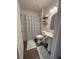 Cozy bathroom with pedestal sink, patterned shower curtain and decorative shelves at 4140 Old Dixie Hwy, Auburndale, FL 33823