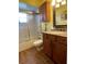 Bathroom with wood cabinets, granite countertop, tile floor, shower with glass door and mermaid decor at 4805 Oak Acres Dr, Lake Wales, FL 33898