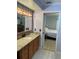 Bathroom with wooden cabinets, granite countertop, and doorway leading to the bedroom at 4805 Oak Acres Dr, Lake Wales, FL 33898