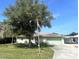 Charming home featuring a well-manicured lawn, an American flag, and an attached two car garage at 4805 Oak Acres Dr, Lake Wales, FL 33898