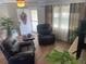 Bright, naturally lit living room with wood-look floors, curtains, and two comfortable recliners at 4805 Oak Acres Dr, Lake Wales, FL 33898
