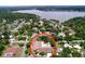 Aerial view of a home with a pool, surrounded by lush greenery and near a picturesque lake at 4966 Foxrun Ln, Lakeland, FL 33813