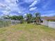 Large grassy backyard with a pergola, white fence and mature trees at 4966 Foxrun Ln, Lakeland, FL 33813