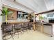 Covered patio bar with a grill, mini-fridge, and comfortable seating at 4966 Foxrun Ln, Lakeland, FL 33813