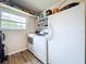 Functional laundry room with a washer, dryer, shelving, a window and a fridge at 4966 Foxrun Ln, Lakeland, FL 33813