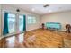 Bright living room features hardwood floors, double doors, and a decorative cabinet at 4966 Foxrun Ln, Lakeland, FL 33813