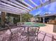 Outdoor patio features seating under a pergola and offers a view of the pool at 4966 Foxrun Ln, Lakeland, FL 33813