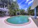 A luxurious pool surrounded by lush tropical landscaping and a cozy patio area at 4966 Foxrun Ln, Lakeland, FL 33813