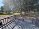 View from deck showing spacious, grassy backyard with mature trees and storage buildings at 5138 Rock Dove Trl, Lakeland, FL 33810